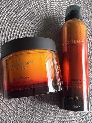 Rituals The Alchemy Collection set - Säljer ett set från Rituals The Alchemy Collection med en body cream och en foaming shower gel. Båda har en lyxig bärnstensfärgad design med svarta lock och detaljer i guld. Dofterna är Amber & Myrrh, perfekt för dig som gillar exklusiva hudvårdsprodukter.