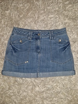 svinsnygg jeanskjol - supersnygg blå jeans kjol med coola fickor, low waist. från kappahl i storlek 36 (S)