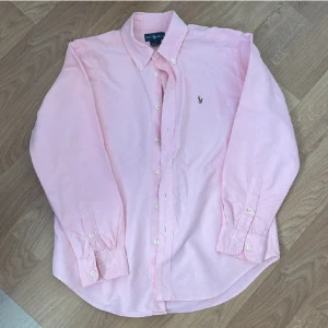 Ralph Lauren Skjorta - Säljer denna asfeta skjortan från Ralph Lauren, säljer den då den är för liten, skjortan är i toppskick utan några skavanker eller fläckar! Perfekta skjortan inför sommaren! Storlek 14 vilket motsvarar ca xs! Skriv vid frågor och funderingar!👍🤝