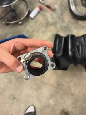 Insugningsrör till moped eller MC - Säljer ett insugningsrör i metall och svart gummi, fyrkantig bas med fyra skruvhål och slangklämma. Perfekt för dig som mekar med mopeder eller motorcyklar och behöver en ny eller extra insugsdel.