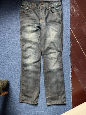 Nudie Jeans Slim Jim Low Coated Denim - Ett par nudie jeans av modellen slim jim, i coated denim. De är i bra skick utan slitage på kanterna av denimet, med fina fades och honeycombs vid knävecken.  W:31 L:32