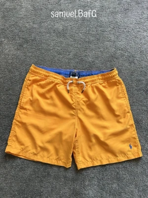 Ralph Lauren Badbyxor - Sköna Orange/Blåa Polo Ralph Lauren badbyxor. Som gjorda för dom varma sommardagarna på stranden. Storlek L/G 14-16. Väldigt bra skick knappt använda.