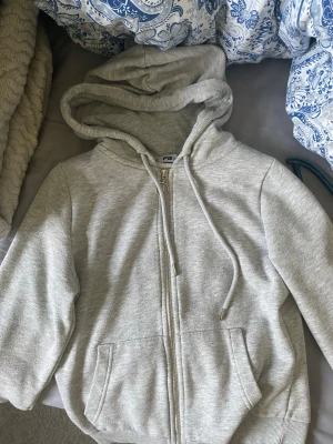 Ljusgrå hoodie  - Ljusgrå hoodie från New Yorker med dragkedja framtill, två fickor och justerbar huva med snören. Enkel och stilren design som passar till det mesta. Jag säljer då den är för liten 💕