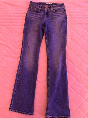 Blå bootcut jeans från Levi's - Säljer dessa blå ”superlow boot” jeans från Levi's i storlek 26/34. De sitter som storlek 36. 