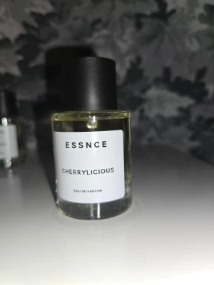 ESSNCE Cherrylicious Eau de Parfum - Parfym från ESSNCE med namnet Cherrylicious. Kommer i en genomskinlig glasflaska med svart lock och vit etikett. Doften är troligen fruktig med inslag av körsbär. Perfekt för dig som gillar söta och fruktiga parfymer.