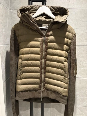 Moncler cardigan  - Säljer en moncler cardigan i storlek L men passar mer åt håller S/M, Den är väldigt snygg och perfekt inför vinter/hösten/våren. Cardiganen är i en stilig olivgrön färg som är väldigt fräsch. Vid funderingar hör av er 😁