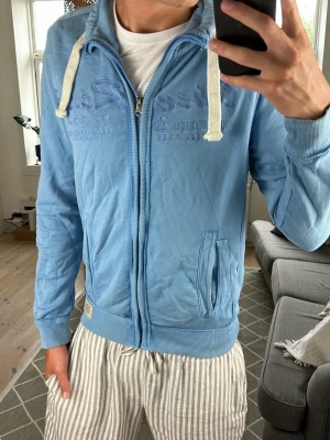 Zip Tröja Blå - Säljer nu denna extremt snygga, unika och betraktade zip tröja från Tom Tailor! Ett litet hål på ena armen men absolut inget som förstör looken! Mått: A:51 B:44 C:40 D:64 (cm) Skriv vid fundering 😇🙌