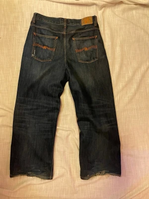 Nudie Jeans Loud Larry  - Säljer ett par mörkblå jeans från Nudie Jeans med wide leg 