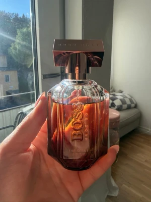 Hugo Boss The Scent Le Parfum 50ml - Säljer en elegant parfym från Hugo Boss, The Scent EdP. Flaskan är i glas med en varm bärnstensfärgad ton och har en lyxig metallkork. Doften är sensuell och modern, perfekt för dig som vill sticka ut med en exklusiv signaturdoft.