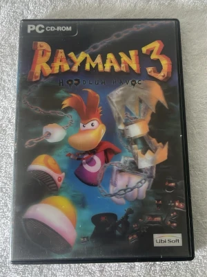 Rayman 3: Hoodlum Havoc PC-spel - Rayman 3: Hoodlum Havoc till PC CD-ROM. Spelet kommer i ett svart plastfodral med färgglad omslagsbild och originalskiva med Rayman-motiv. Ett klassiskt plattformsspel med tecknad grafik och äventyrskänsla. Perfekt för dig som gillar action och humor i spel.