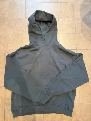 Mörkgrå hoodie Acne Studios - Säljer en mörkgrå hoodie från Acne Studios med stor huva och tryck på ryggen där det står 'Acne Studios STOCKHOLM 1996'. Hoodien har en avslappnad passform och är tillverkad i mjukt bomullsmaterial. Perfekt för en chill och stilren look.