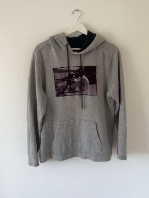 Grå limitato hoodie - Snygg grå hoodie från limitato med en ruggigt kaxig svart vit bild på bröstet. Om man villa några mott är de bara att höra av sig 