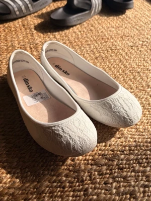 Vita ballerinaskor med spets - Säljer ett par vita ballerinaskor med spets från Din Sko i storlek 35. Endast provade!🥰