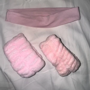 Set med rosa hårband och scrunchies - Säljer ett set med ett ljusrosa stretchigt hårband och två fluffiga scrunchies i mjuk, pastellrosa fuskpäls. Perfekt för att hålla håret borta när du sminkar dig eller vill ha en söt accessoar. Inget synligt märke.