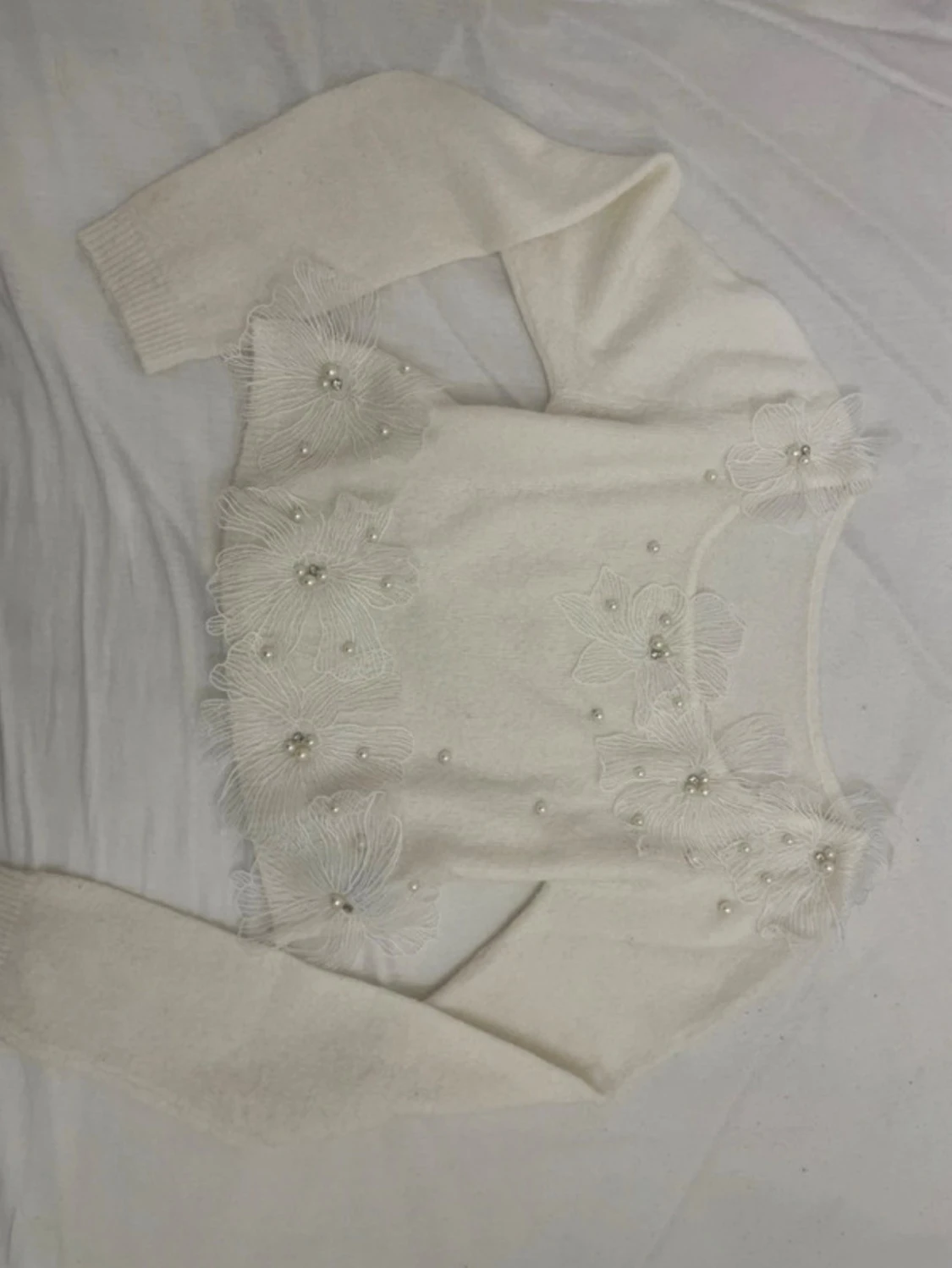 Vit stickad tröja med pärlor och blommor