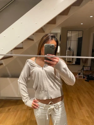 Ljusgrå croppad zip hoodie - Trendig ljusgrå croppad hoodie med dragkedja framtill och långa ärmar.