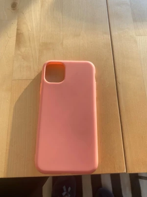 Korall silikon skal till iPhone - Snyggt korall mobilskal i mjukt silikonmaterial som passar iPhone. Skalets design är enkel och stilren med rundade hörn och ett stort kamerahål. Perfekt för dig som vill ha ett färgglatt och smidigt skydd till mobilen.IPhone 11,helt ny