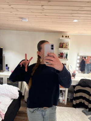 Mörkblå stickad tröja Gina Tricot - Mysig mörkblå stickad tröja från Gina Tricot. Tröjan har en enkel och klassisk design med rund halsringning och långa ärmar. Perfekt för att hålla värmen under kyliga dagar.