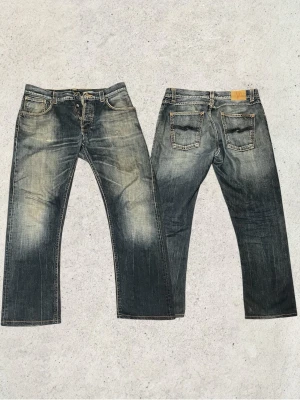 Nudie jeans – Easy Emil - Riktigt snygga Nudie jeans i modellen Easy Emil. Jeans i storlek W32 L36, men de är uppsydda och bör passa dig som är cirka 180–185 cm. Har galet snygga fades som ger jeansen ett riktigt schysst och använd look. Ett par som verkligen sticker ut och bara blir snyggare med tiden. Vid fler funderingar är det bara att skriva mvh FABIANFASHION     Mått 🚨🚨🚨🚨🚨Midja :44cm  Längd : 98cm  Ben öppning: 21