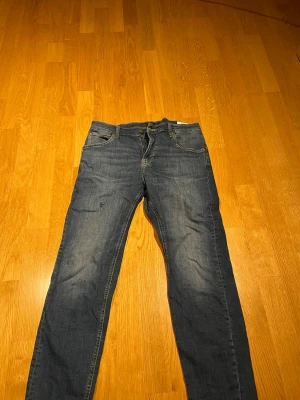 Lee Jeans Austin - Säljer nu ett par riktigt feta jeans från Lee i modellen Austin. Snygg färg med fade och några få slitningar. Sitter mycket bra och har inga större tecken på slitage som tex i skrevet.  Midja : 40 cm Ytterbensmått : 94 cm Innerbensmått : 70 cm  Kolla gärna in mina andra annonser och hör av er vid minsta fråga/ fundering!  Mvh Harry