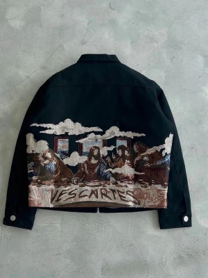 Vescartes - Last Supper jacka - Nypris 1300! - Unik svart jacka från Vescartes med detaljerade broderier inspirerade av klassisk konst på både fram- och baksida. Jackan har krage, dragkedja framtill och quiltat innerfoder. Broderade moln och figurer ger en konstnärlig vibe. Storlek L men passar som en boxy fit M.
