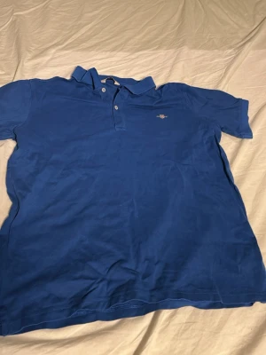 Blå pikétröja från Gant - Säljer denna blåa pikén från Gant i storlek 176.