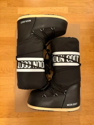 Svarta Moon Boot storlek 39-41 - Säljer ett par svarta moon boot som endast testats inomhus så finns inget slitage, skulle påstå att dom rå i nyskick. Köpta för 2300 och orginalbox följer med ✨