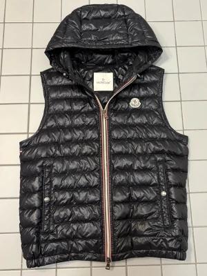 Moncler väst - Säljer denna feta Moncler väst med luva | Bra skick | Modell: Gien | Eftertraktad modell, säljs ej längre | Storlek 2 motsvarande S/M | Nypris: 10k Mitt pris: 3299 | Skriv vid minsta fråga eller fundering 🤝