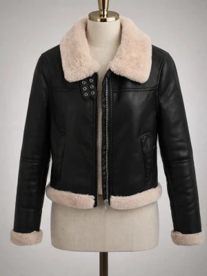 Svart skinnjacka med fuskpäls - Snygg svart skinnjacka med krage, ärmslut och nederkant i beige fuskpäls. Jackan har dragkedja framtill, två sidofickor och coola metallöglor vid halsen. Perfekt för dig som vill ha en trendig och varm look i vinter. RÖKFRI.