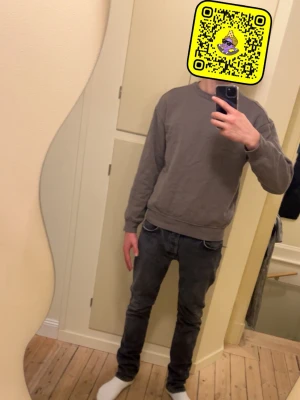 Brun sweatshirt med rund hals - En basic brun sweatshirt med rund hals och långa ärmar. Tröjan har ribbade muddar vid ärmslut och nederkant, perfekt för en avslappnad stil. Passar till jeans eller mjukisbyxor för en chill look.