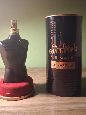 Jean Paul Gaultier Le Male Parfum 125ml - Parfymen Jean Paul Gaultier Le Male Le Parfum i en ikonisk svart flaska formad som en manlig torso. Kommer i en elegant svart och kopparfärgad metallburk. Flaskan rymmer 125 ml och har en lyxig och modern design.