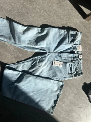 Ljusblå flare jeans från lager 157 - Säljer ett par ljusblå jeans från Lager 157 med flare passform. Jeansen har aldrig använts och har prislapp kvar. Jeansen sitter strax ovanför midjan. Pris kan diskuteras.