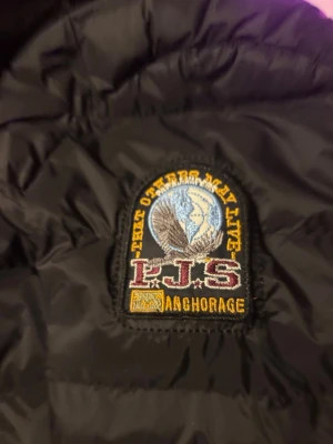 Svart pufferjacka från Parajumpers - Säljer en svart pufferjacka från Parajumpers i modellen Super Lightweight. Jackan har quiltad design, hög krage och diskret logga på ärmen. Perfekt för kalla dagar och enkel att matcha med olika outfits. Materialet är lätt och smidigt men ändå värmande.