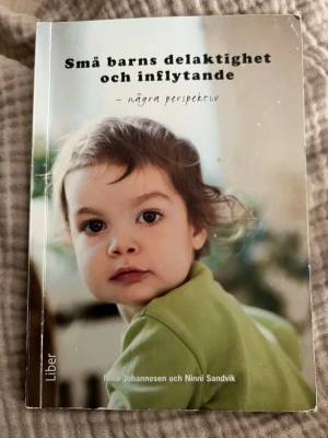 Små barns delaktighet och inflytande - Kursbok om små barns rätt till delaktighet och inflytande i förskolan, skriven av Nina Johannesen och Ninni Sandvik. Boken tar upp pedagogiska miljöer, barns perspektiv och ramplaner. Mjukpärm med omslagsbild i gröna och beige toner.