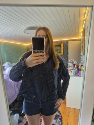 Mörkblå mönstrad blus från Esprit - Snygg mörkblå blus från Esprit med diskret vitt mönster. Blusen har v-ringning och långa ärmar med lätt puff vid axlarna. Perfekt att styla med jeans eller kjol för en trendig look.