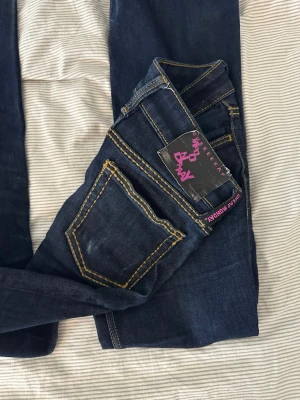 Mörkblå jeans från Cheap Monday - Snygga mörkblå jeans från Cheap Monday med klassisk femficksmodell och kontrasterande gula sömmar. Tyvärr blivit för små, har små slitningar längst ner. Storlek w26l32 