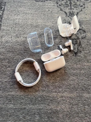 Apple AirPods Pro 2 med tillbehör - Säljer ett par vita Apple AirPods Pro med laddningsetui, extra silikontoppar och genomskinligt skyddsfodral. In-ear design med stilren och kom. bra ljud och smidig laddning.