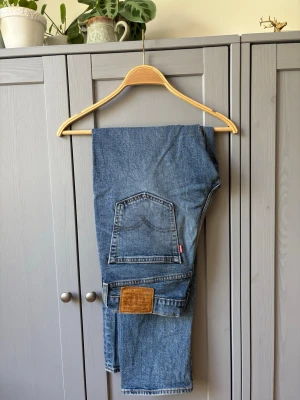 Levi's 514  31/32 - Klassiska Levi's 501 jeans i ljusblå denim med raka ben och femficksmodell. Jeansen har knappgylf och den ikoniska läderpatchen bak i midjan. Perfekta för en avslappnad och tidlös stil.