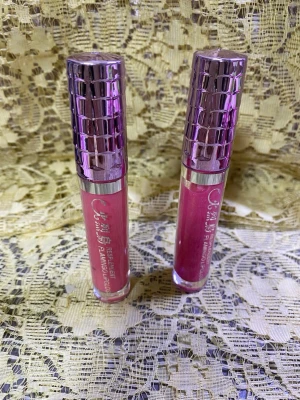Rosa läppglans med metalliclock - Två snygga rosa läppglans med glansig finish och coolt metallicfärgat lock i lila. Tuben är genomskinlig så man ser färgen tydligt. Perfekt för dig som vill ha en fräsch och glansig look på läpparna. Helt ny 