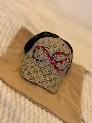 GG keps - En keps med en orm logo på, Kommer med dustbag. Priset kan diskuteras!