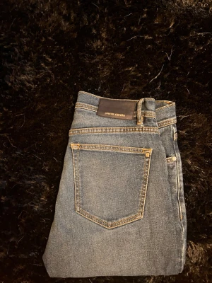 Blå jeans från Pierre Cardin - Klassiska blå jeans från Pierre Cardin med raka ben och femficksmodell. Jeansen har kontrastsömmar och en läderpatch med logga bak i midjan. Perfekta för en avslappnad och stilren look.