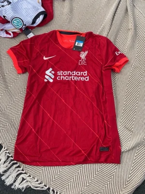 Liverpool FC matchtröja röd Nike - Säljer en röd Liverpool FC matchtröja från Nike med vita detaljer och klubbmärke på bröstet
