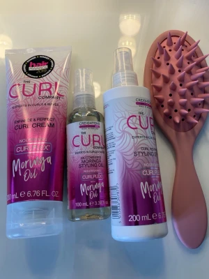 The Curl Company hårvårdspaket - Säljer ett hårvårdspaket från The Curl Company med curl cream, moringa styling oil och curl reviving styling spray, alla med moringaolja. Medföljer en rosa silikonborste med piggar, perfekt för lockigt hår. Produkterna har testats några få gånger. 