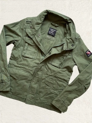 Superdry Fieldjacket - En mycket trevlig fieldjacket från Superdry i en fin ton av grön! Sitter som en XS! Hör av dig vid frågor! 
