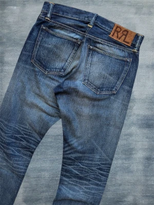 *GALEN WASH* RRL SELVEDGE JEANS - Ett par helt otroliga selvedge jeans från Double RL med en av de sjukaste tvättarna jag sett! Storlekslappen är borta men måtten är angivna nedan, proffesionellt insydda lite grann i midjan. Hör av dig vid frågor! Mått: Midja - 40 cm, Ytterbenslängd - 105 cm, Benslut - 18.5cm 
