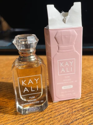 Kayali Yum Boujee Marshmallow 81, 5ml - Nyköpt här om veckan, endast testat ett par droppar!          Kayali Yum Boujee Marshmallow 81 är en söt parfym i en liten, lyxig glasflaska med kristalliknande lock. Flaskan är transparent och kommer med en ljusrosa kartong. Doften är gourmand och passar dig som gillar marshmallow och söta toner.