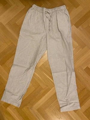 Beiga linnebyxor - Snygga beiga linnebyxor med avslappnad passform. Storlek M. 