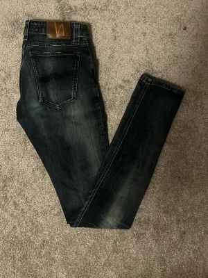 Mörkblå jeans från Nudie Jeans - Tja säljer ju dem här snygga och stilrena jeansen från Nudie! Storlek W28, L34! Skick 9/10! Färg mörkblåa! Model Skinny Linn! Pris endast 299kr! Hör av er vid minsta lilla fråga eller fundering! 