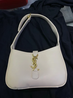 Saint Laurent väska - En jättefin ljusbeige väska från Saint Laurent (YSL). En lyxig väska som passar till alla outfits.