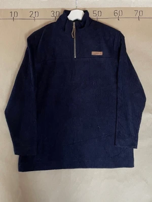 Mörkblå manchestertröja Lauren RL- Ralph Lauren - Mörkblå långärmad fleece tröja i manchestertyg från Lauren RL. Tröjan har halv dragkedja framtill och en liten patch med logga på bröstet. Perfekt för dig som gillar en avslappnad men stilren look. Storlek small, pris kan diskuteras 